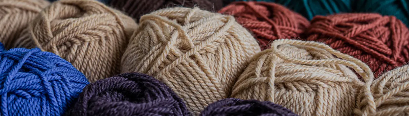 Close-up of various colorful balls of high-quality yarn used by Ruijing Textile for manufacturing custom knit sweaters and blankets.